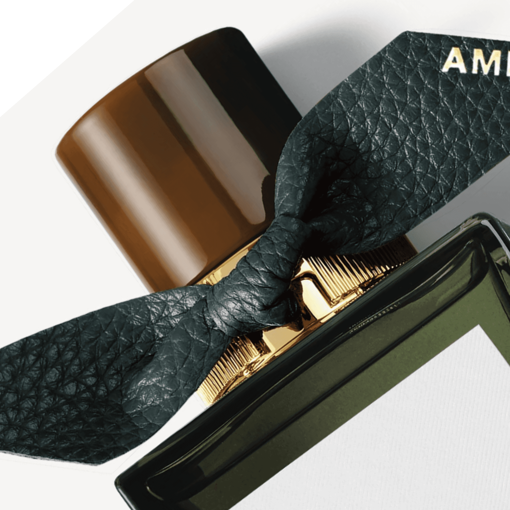 Close-up of Burberry Midnight Journey EDP 100ml cap and textured black bow with gold initials, highlighting premium design details.